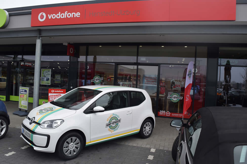 Parkendes Firmenauto von MegaRepair vor Vodafone Shop Henstedt-Ulzburg.  